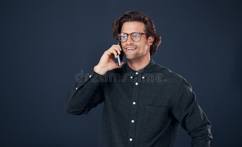 Happy man, glasses and talking with phone call in discussion or communication on a dark studio background. Handsome stock images