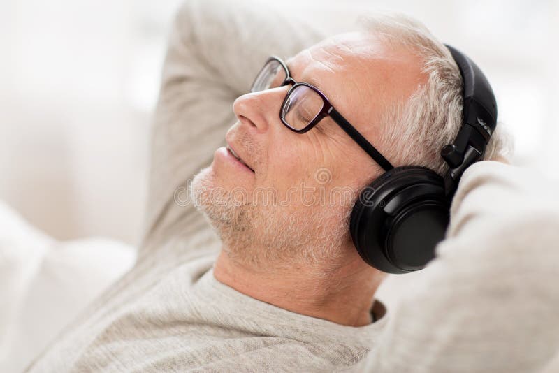 Happy man in headphones listening to music at home