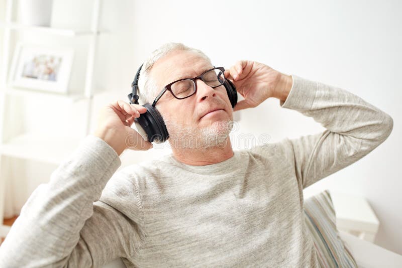 Happy man in headphones listening to music at home