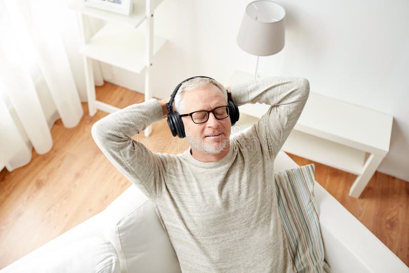 Happy man in headphones listening to music at home