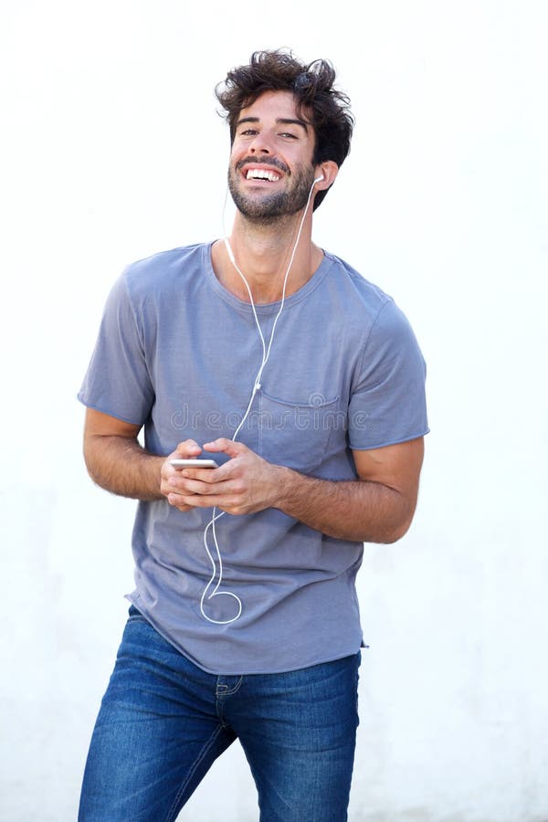 Happy man holding mobile phone listening to music