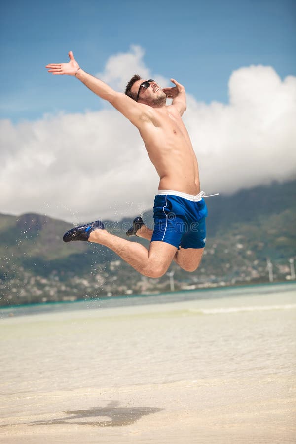 Happy man jumping of joy on the beach