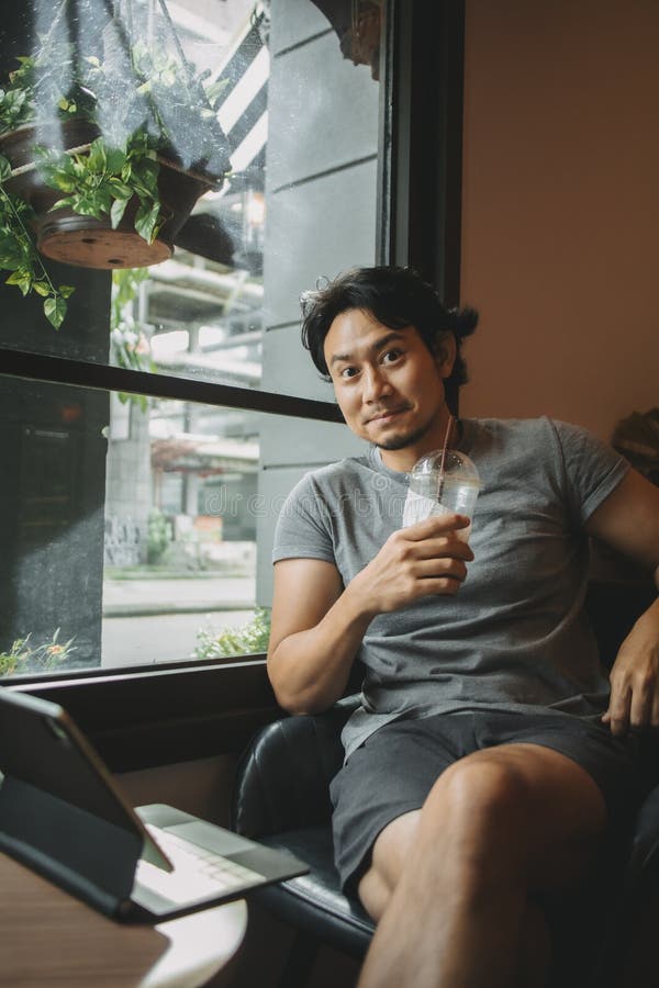 Happy man relaxed in the cafe, drinking iced coffee. royalty free stock photo