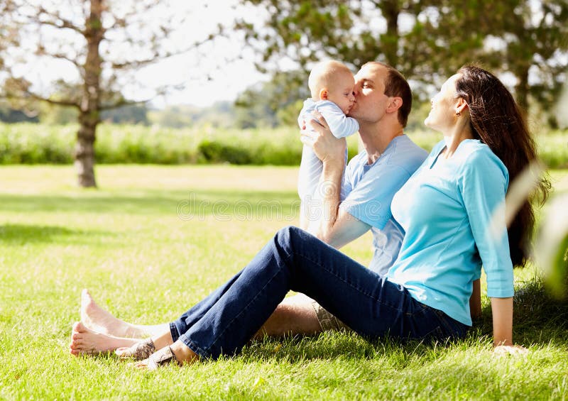 Happy Man Sitting With Wife And Kissing Little Son Stock Image