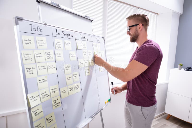 Happy Man Sticking Adhesive Note On White Board