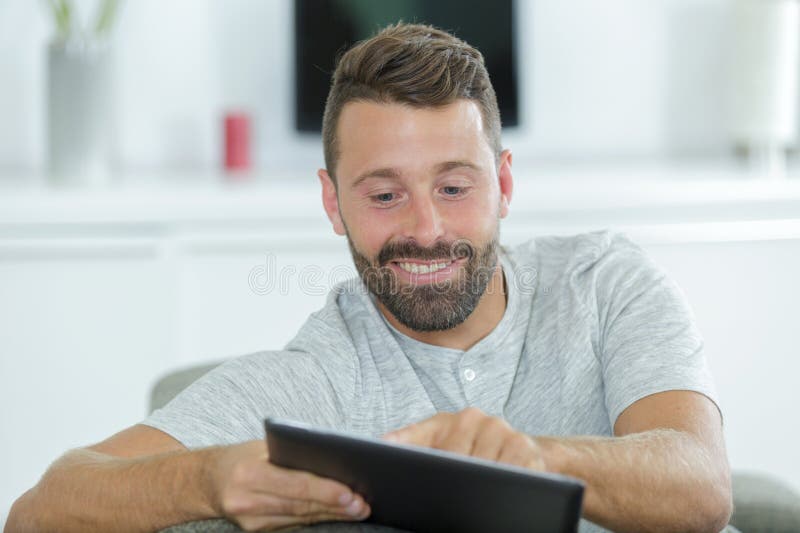 Happy man with tablet pc computer at home royalty free stock image