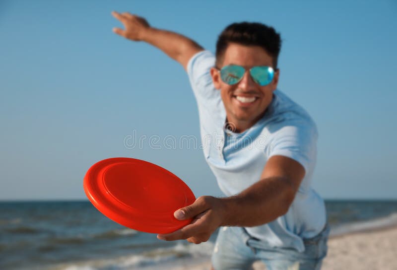 Happy Man Throwing Flying Disk at Beach, Focus on Hand Stock Image