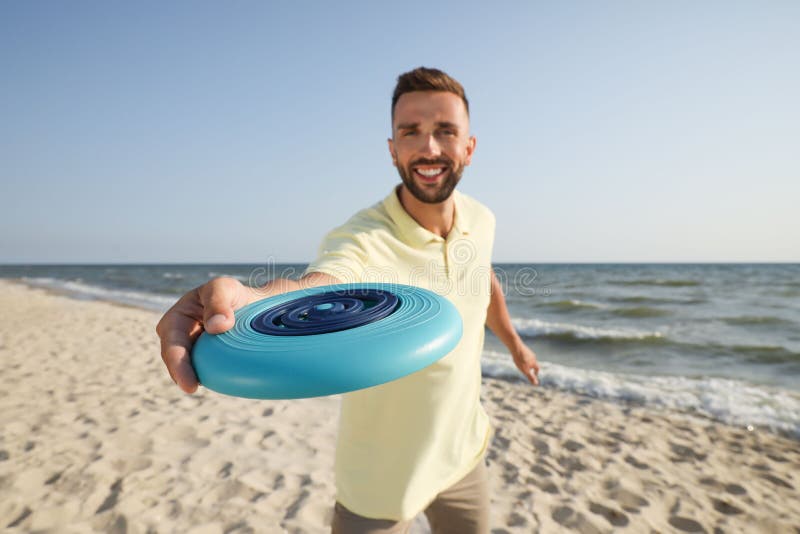 Happy Man Throwing Flying Disk at Beach, Focus on Hand Stock Image