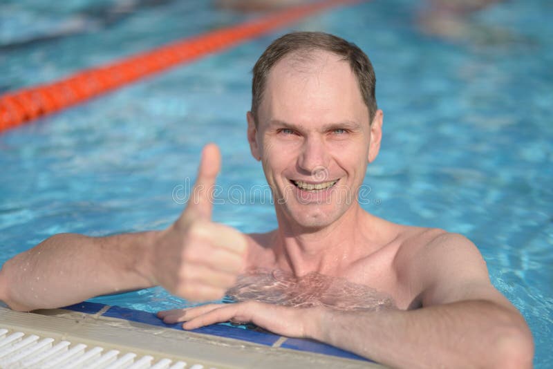 Happy man with thumbs up in a swimming pool