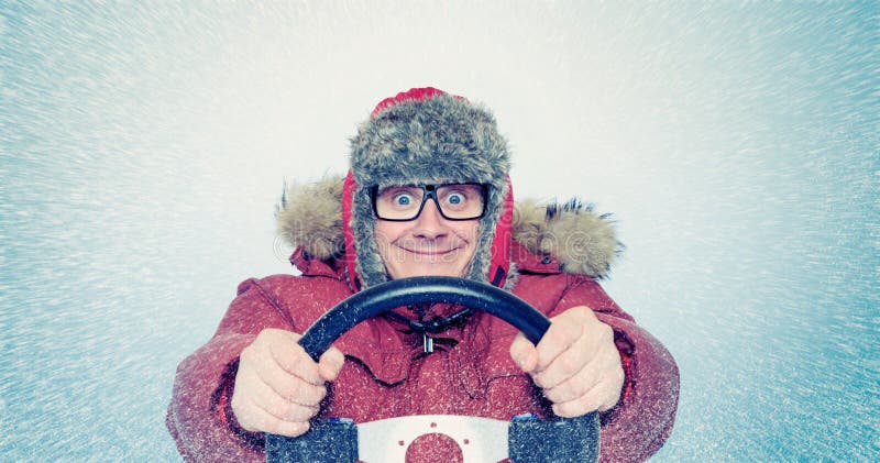 Happy Man in winter clothes with a steering wheel, snow blizzard. Concept car driver royalty free stock photo Happy Man in winter clothes with a steering wheel, snow blizzard. Concept car driver royalty free stock photo