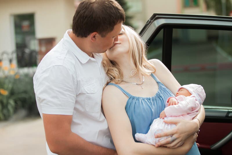 Happy Mann küsst seine Frau mit dem Neugeborenen stockfotografie