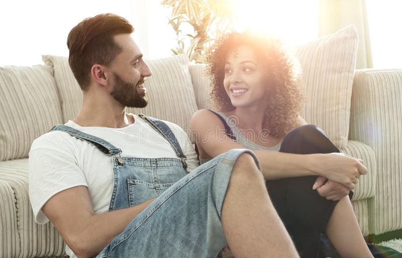 Happy married couple sitting on the carpet in a new apartment. stock photography Happy married couple sitting on the carpet in a new apartment. stock photography