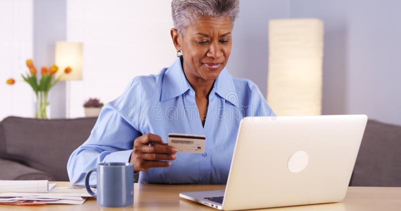 Happy Mature African woman buying things online royalty free stock photography Happy Mature African woman buying things online royalty free stock photography