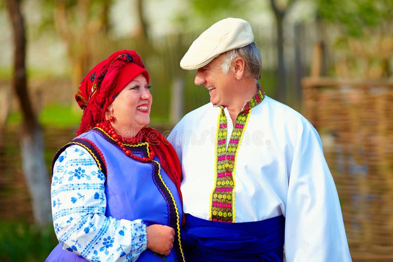 Happy mature couple in traditional ukrainian clothes. Mature ukrainian couple in traditional costumes talking in village street stock image Happy mature couple in traditional ukrainian clothes. Mature ukrainian couple in traditional costumes talking in village street stock image