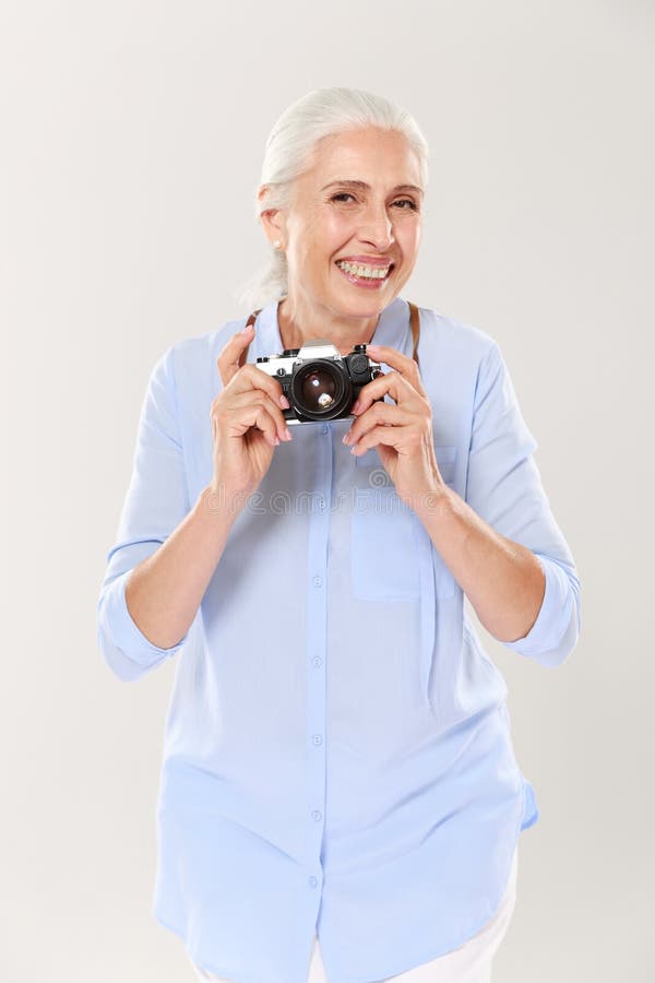 Happy mature woman holding retro camera isolated over white stock photos Happy mature woman holding retro camera isolated over white stock photos