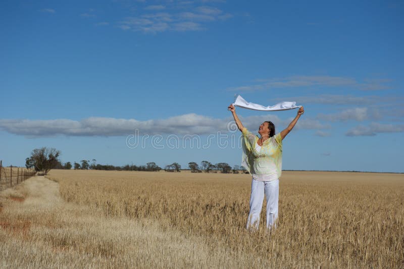 Happy Mature Woman in Field of Wheat