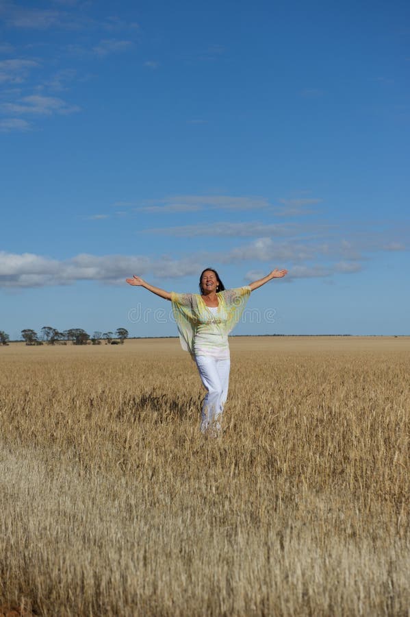 Happy Mature Woman in Field of Wheat