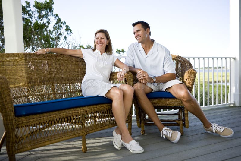 Happy mid-adult couple sitting together on terrace stock photo Happy mid-adult couple sitting together on terrace stock photo