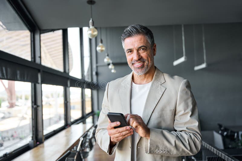 Happy Mid Aged Business Man Holding Mobile Cell Phone in Office ...