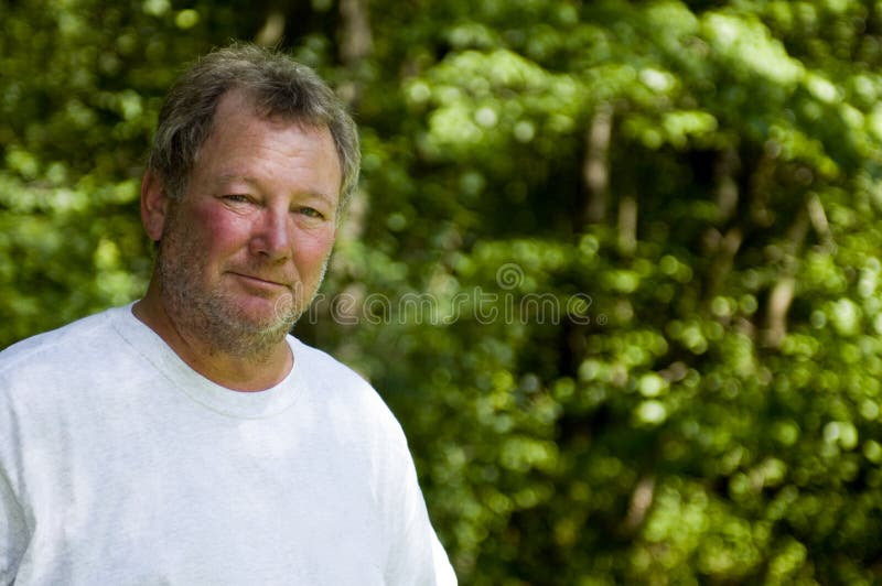 Happy middle age man wooded background