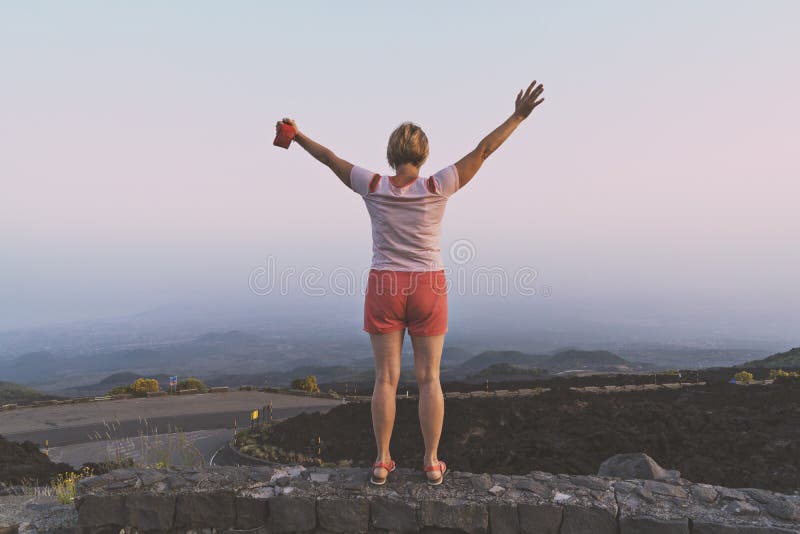 Happy middle-aged woman with raised hands