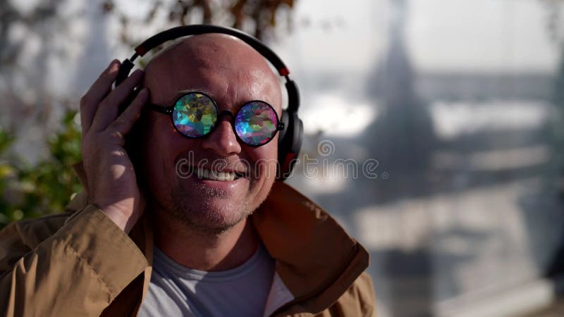 Happy Middleaged Man genießt sein Lieblingslied durch Kopfhörer auf Straßenhipster in der Stadt