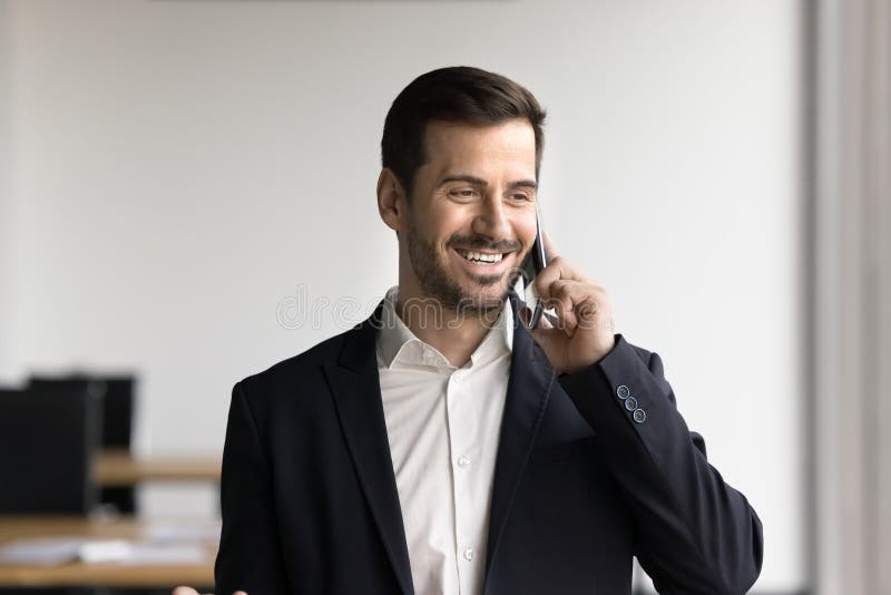 Happy millennial businessman solving business related matters by phonecall stock photo