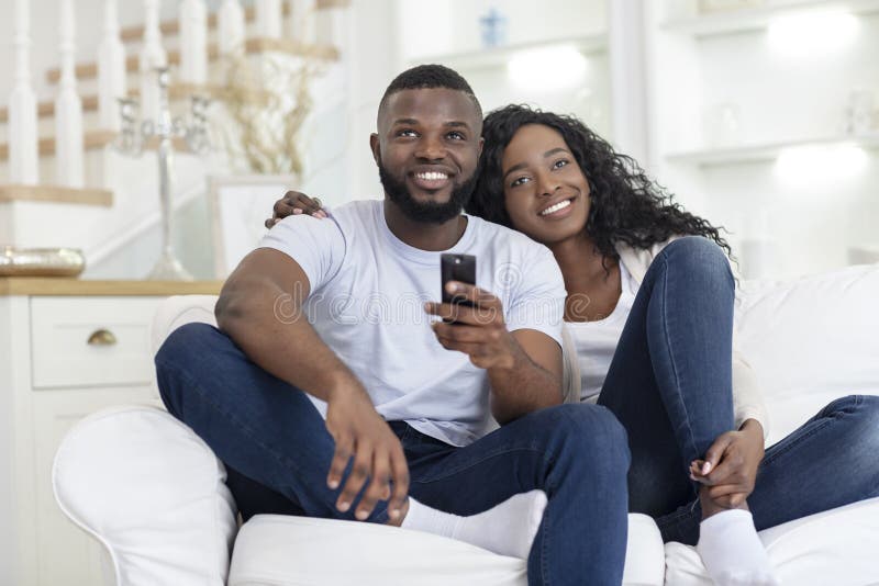 Happy Millennial Couple Embracing and Watching TV, Sitting on Sofa ...
