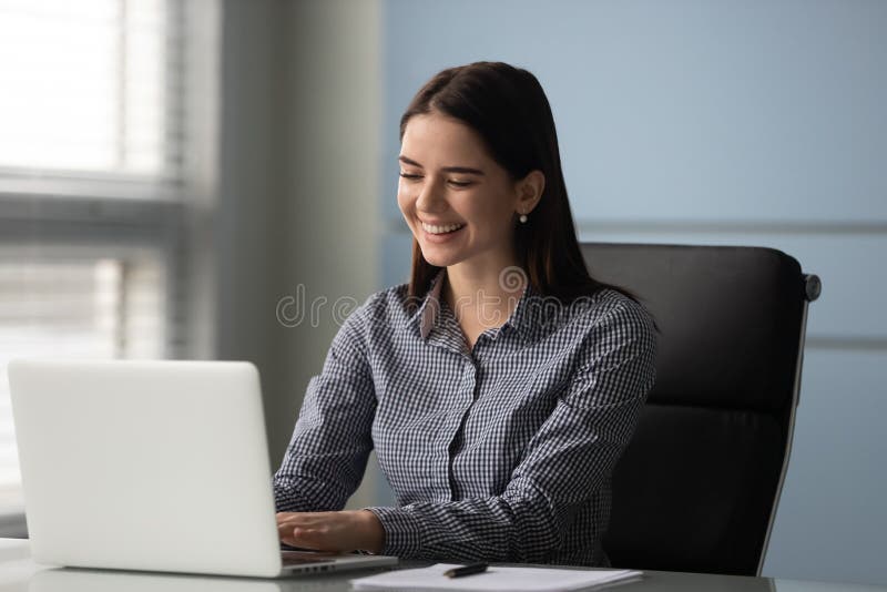 Happy millennial female employee manager working with computer at office. royalty free stock image