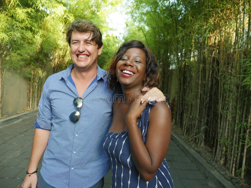 Happy mixed ethnicity couple cuddling outdoors with attractive black African American girlfriend or wife and handsome Caucasian stock photos Happy mixed ethnicity couple cuddling outdoors with attractive black African American girlfriend or wife and handsome Caucasian stock photos