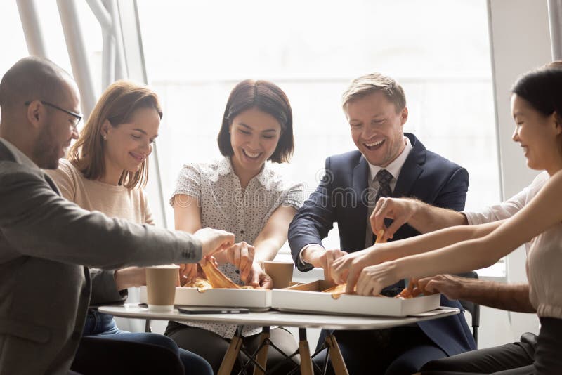 Happy mixed race company workers sharing lunch, eating pizza. stock photos Happy mixed race company workers sharing lunch, eating pizza. stock photos