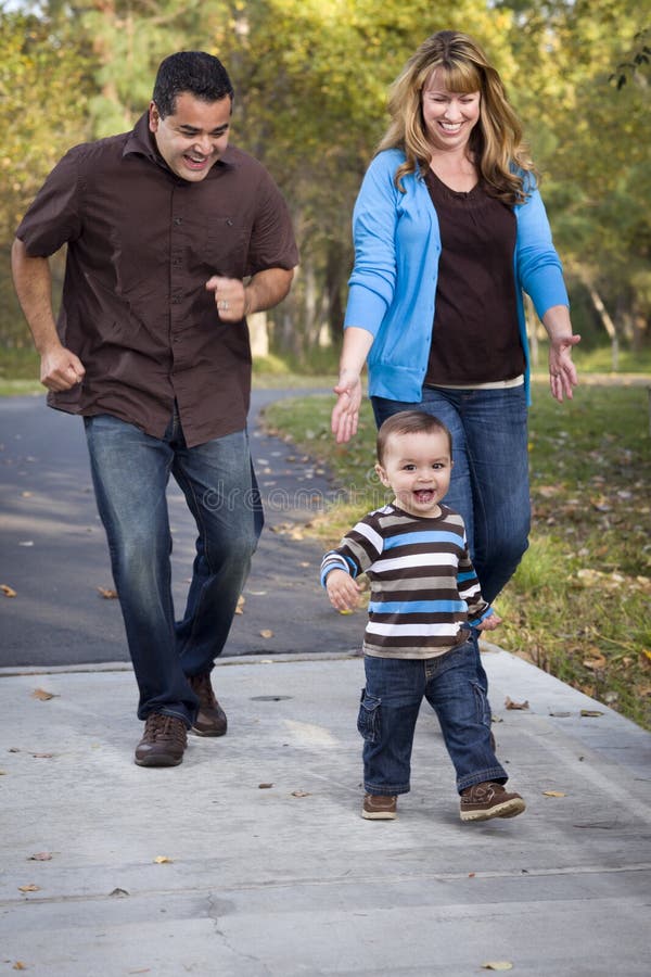 Happy Mixed Race Ethnic Family Walking In The Park