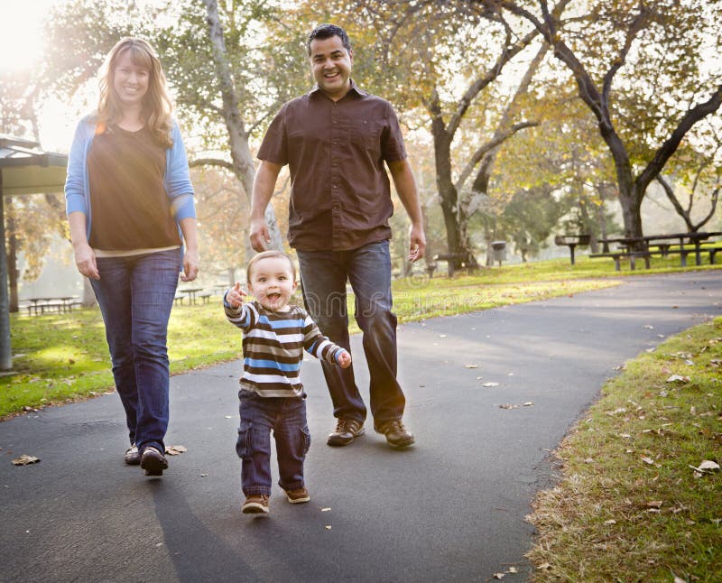 Happy Mixed Race Ethnic Family Walking In The Park