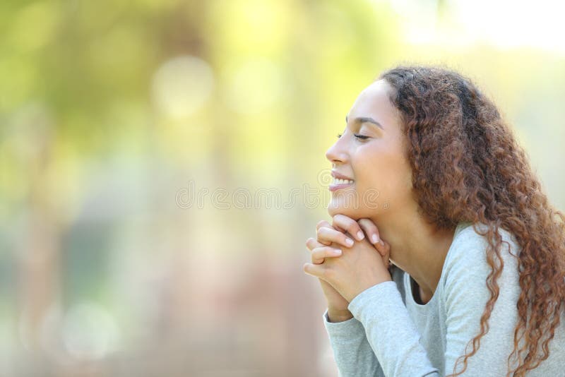 Happy mixed race woman meditating outdoors