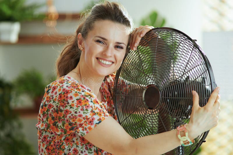 Happy modern female hugging electric fan stock photos Happy modern female hugging electric fan stock photos
