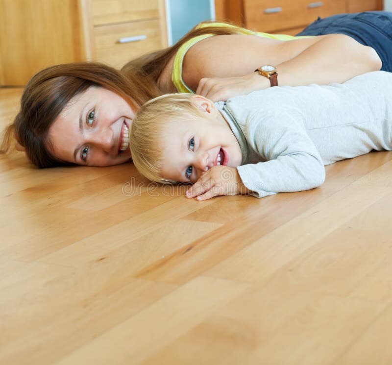 Happy mom and child on wooden floor