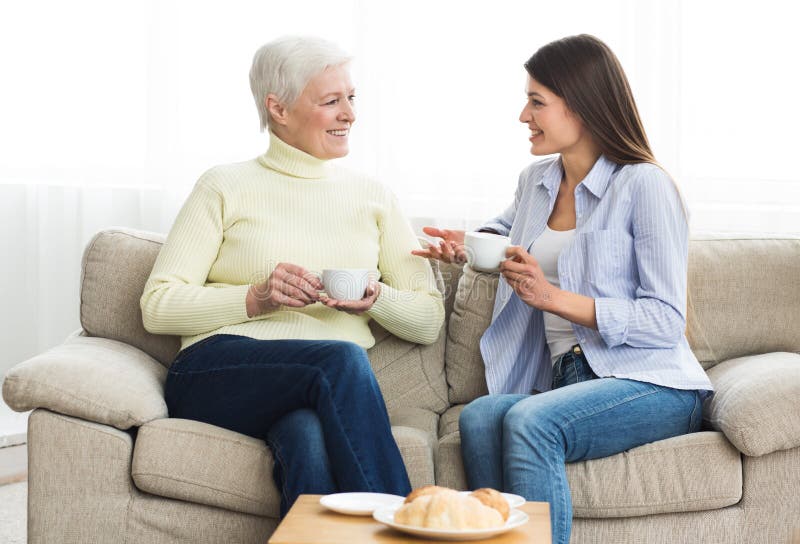 Happy mom and daughter talking and drinking tea royalty free stock photos Happy mom and daughter talking and drinking tea royalty free stock photos