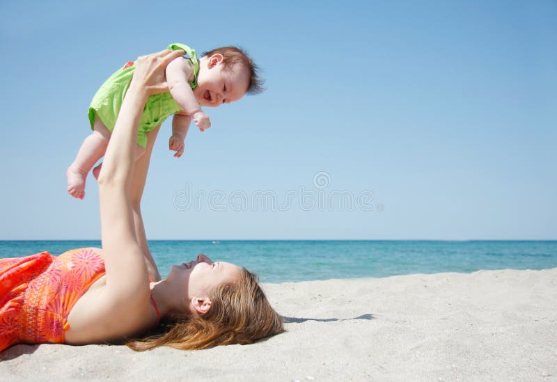 Happy mother and baby on beach