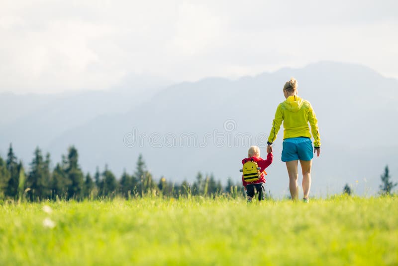 Happy mother with baby boy walking on green meadow royalty free stock image Happy mother with baby boy walking on green meadow royalty free stock image