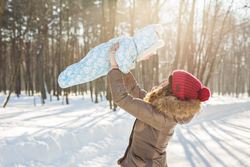 Happy mother and baby in winter park. family outdoors. cheerful mommy with her child