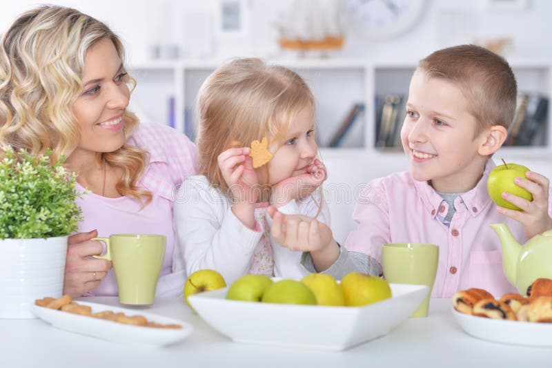 Happy mother and children having breakfast together stock photos Happy mother and children having breakfast together stock photos
