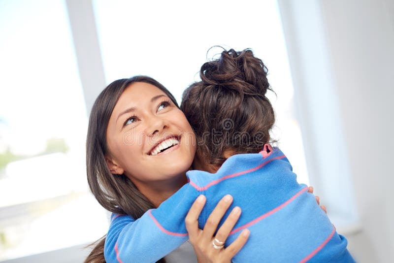 Family, children, love and happy people concept - happy mother and daughter hugging at home