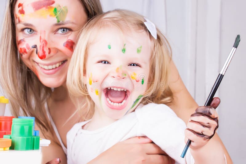 Happy mother and daughter painting