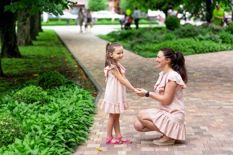 Happy Mother And Daughter 5 6 Years Old Walk In The Park In The Summer Mother Talks To Her 