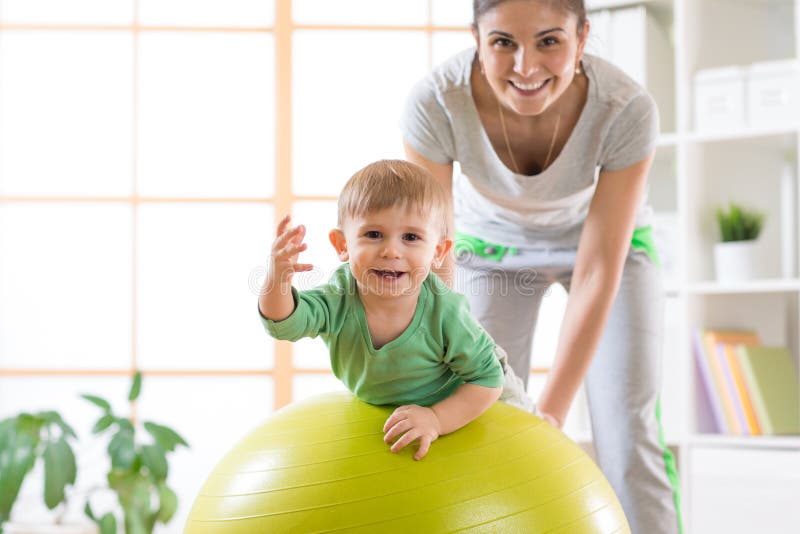 Happy mother and her baby on fitness ball. Gimnastics for kids on fitball. royalty free stock image Happy mother and her baby on fitness ball. Gimnastics for kids on fitball. royalty free stock image