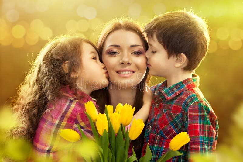 Portrait of children kissing her mother with flowers. Spring, March 8, International Womens, Mothers day, family holiday. Portrait of children kissing her mother with flowers. Spring, March 8, International Womens, Mothers day, family holiday