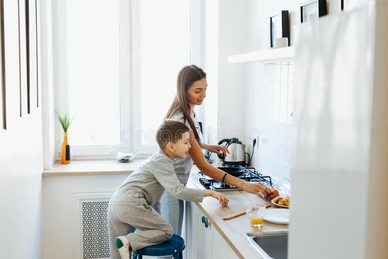 Happy mother with son cooking omelet in kitchen at home stock images Happy mother with son cooking omelet in kitchen at home stock images