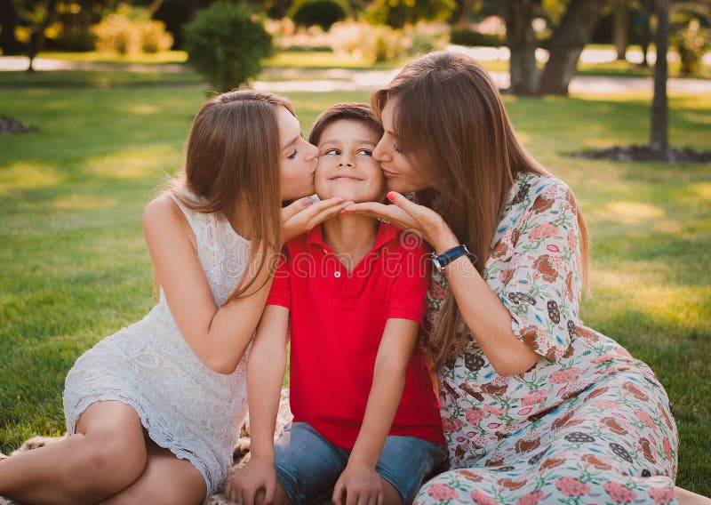 Mother daughter Happy Kiss. Мом энд систер всех. Happy mom watches son and daughter kissing. Mother playing with her daughter in the Park.