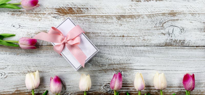 Happy Mothers Day concept with gift box and pink tulips on white aged wood royalty free stock images Happy Mothers Day concept with gift box and pink tulips on white aged wood royalty free stock images