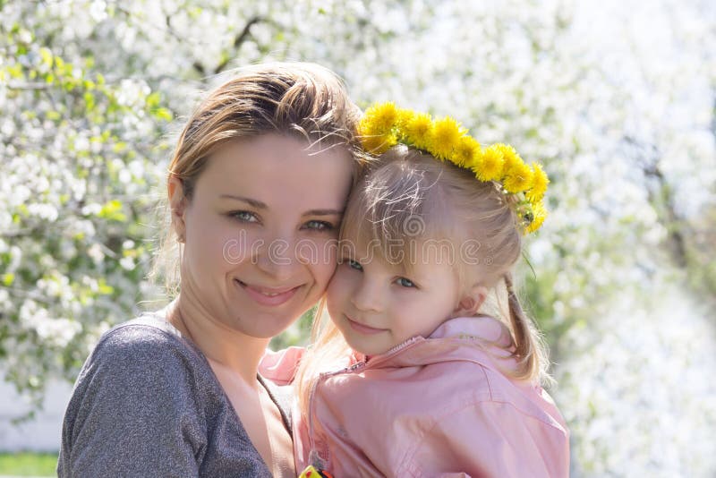 Happy mothre and baby girl in spring garden